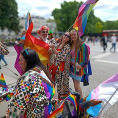 some people are standing in the street with kites