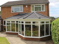 a brick house with a tiled roof and white windows