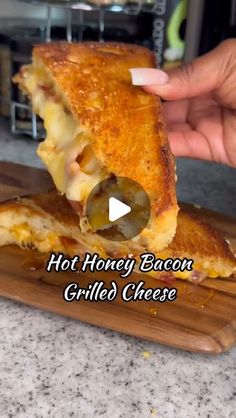 someone is holding up a grilled cheese sandwich on a cutting board with the words hot honey bacon grilled cheese