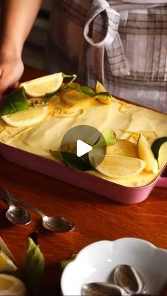 a person cutting up some food on top of a wooden table with spoons and plates