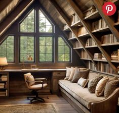 an attic office with bookshelves, desk and couch in the middle of it