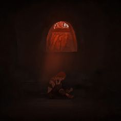 a person sitting on the ground in front of a dark tunnel with red light coming from it