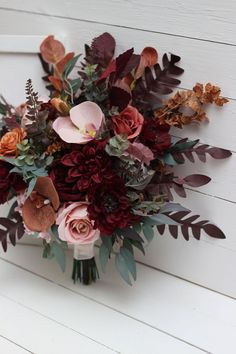 a bouquet of flowers sitting on top of a white wall