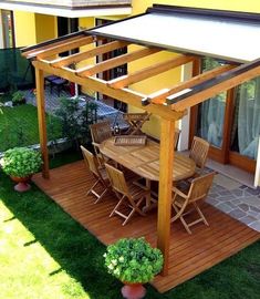 an outdoor dining area with table and chairs, covered by a white awning over it