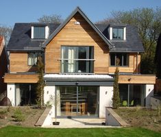 a large wooden house sitting on top of a lush green field