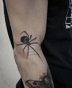 a man with a spider tattoo on his arm and an eyeball in the center