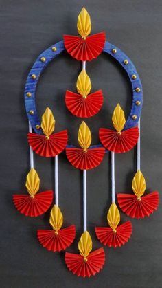 an art piece with red, yellow and blue paper fans