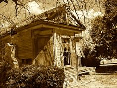 sepia photograph of an old outhouse in the country