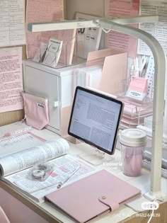 a desk topped with lots of papers and a computer on top of it's stand