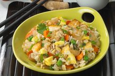 a yellow bowl filled with rice and vegetables