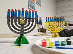 a hanukkah menorah sits on a table with crayons and watercolors