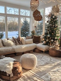 a living room filled with lots of furniture and a christmas tree in the window sill