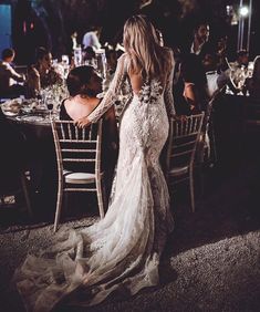 the back of a woman's dress at a dinner table with people sitting around