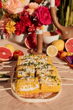 corn on the cob with flowers and other fruit in the backgroung