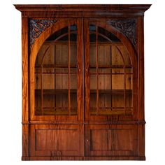 an old wooden bookcase with glass doors and carvings on the front, isolated against a white background