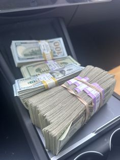 stacks of money sitting in the center console of a car, on top of each other