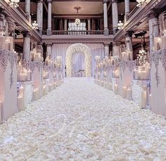 an elaborately decorated wedding ceremony hall with candles in the center and flowers on the floor