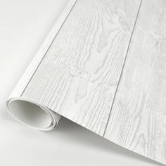 a white wooden wallpaper with a roll of paper