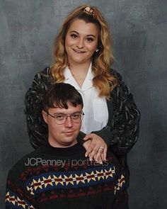 a man sitting on the back of a woman's head in front of a gray background