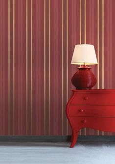 a red dresser with a lamp on top