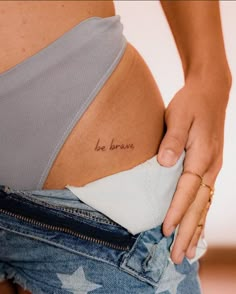 a woman's stomach with the word be brave written on it, in small font