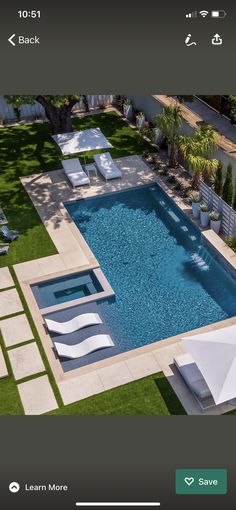 an aerial view of a pool with lawn chairs and umbrellas