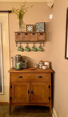 a kitchen area with a wooden cabinet and coffee pot on the top shelf above it