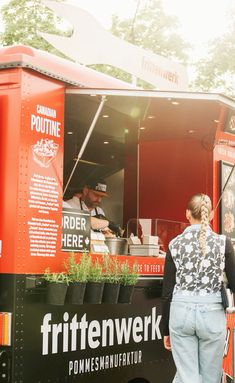 a woman standing in front of a food truck