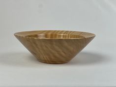 a wooden bowl sitting on top of a white table