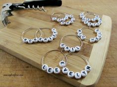 a wooden cutting board topped with lots of wine charms