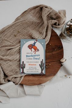 a book sitting on top of a wooden plate next to a bag and some spices