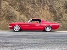 a red sports car parked in front of a mountain