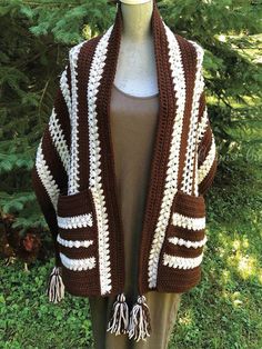 a brown and white crocheted shawl with tassels