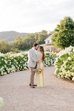 a bride and groom standing in front of white flowers at the end of their wedding day