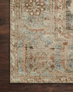 an area rug with brown, blue and beige colors on top of wooden flooring