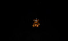 a teddy bear is sitting in the dark