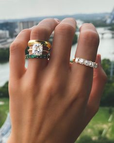 a woman's hand with two rings on top of her finger, and the other ring