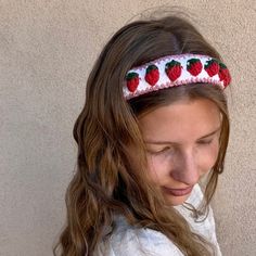 a girl wearing a headband with strawberries on it