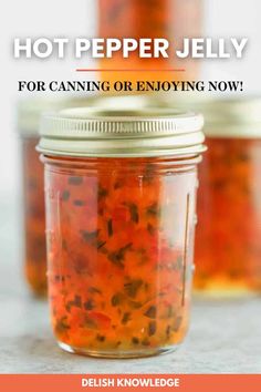 two jars filled with hot pepper jelly sitting on top of a counter next to the words hot pepper jelly for canning or enjoying now