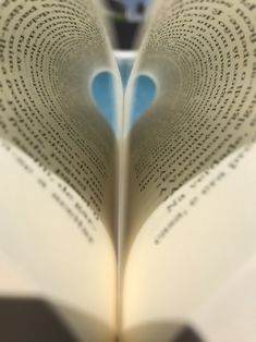 an open book with pages shaped like a heart