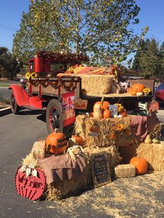 a truck with hay bales and pumpkins in the back