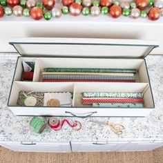 an open box filled with lots of crafting supplies on top of a white counter