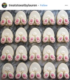 the cookies are decorated with pink and white icing on top of a marble table