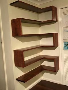 some shelves in the corner of a room that is painted white and has wood trim