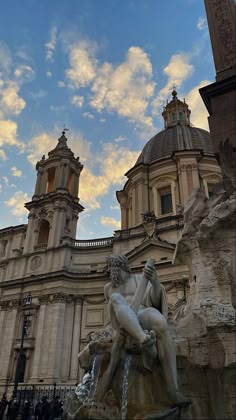 the statue is sitting in front of an old building