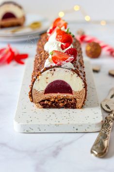 a piece of cake with strawberries and cream on it sitting on a marble platter