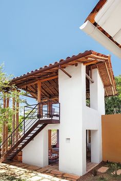 a white house with a wooden roof and stairs