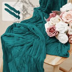 a bouquet of flowers sitting on top of a wooden chair next to a green blanket