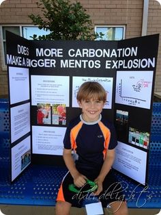 a young boy is sitting on a bench in front of a sign that says more carbonation, make bigger mentos explosion