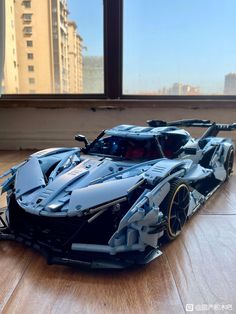 a toy batmobile is sitting on the floor in front of a window